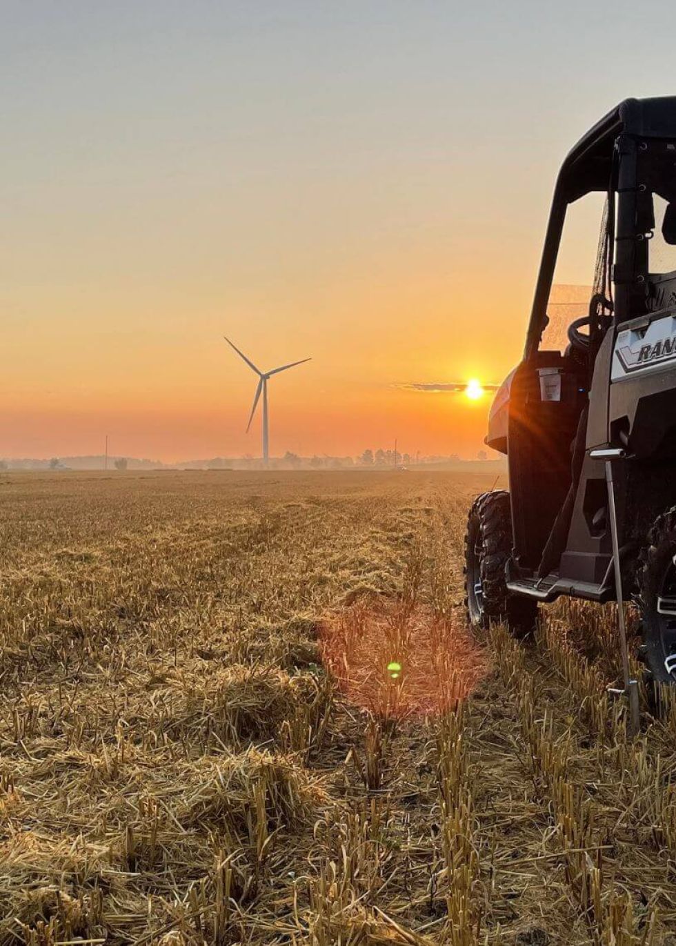 One of Holmes Agromart's vehicles on the field at sunset.
